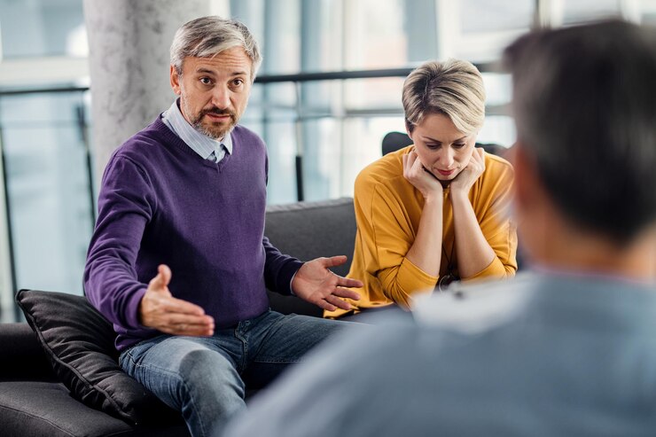 mid-adult-man-talking-marriage-counselor-while-being-with-his-wife-couple-therapy_637285-11110